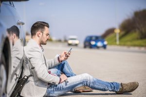 Man Sitting Near Car Needs Roadside Assistance
